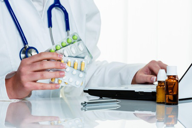 Image of doctor holding  prescription capsules 