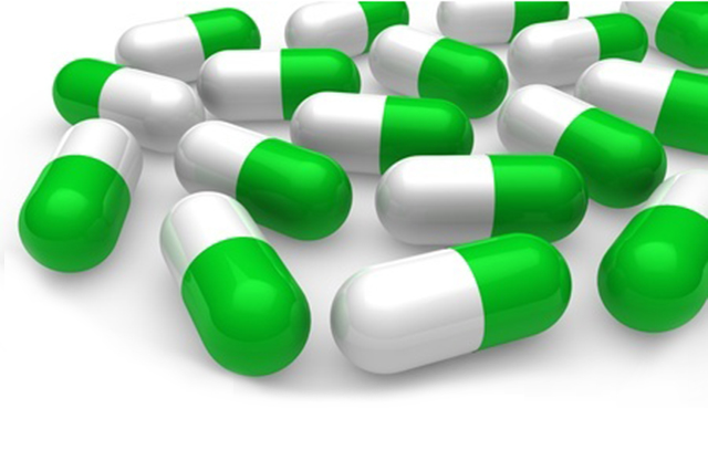 Image of medicine capsules coloured gree and white