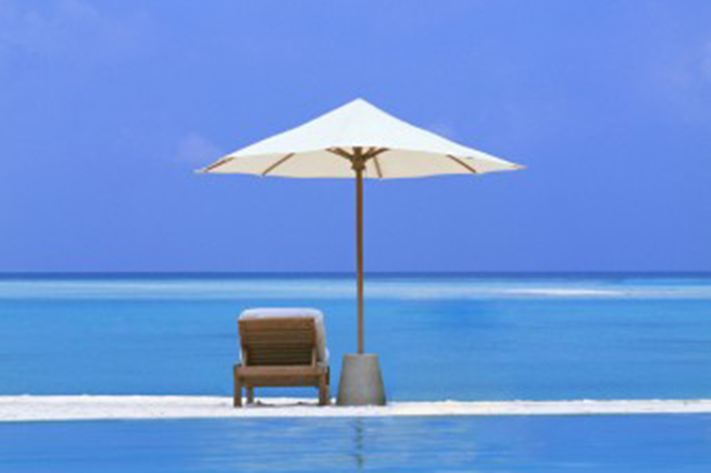 Idyllic photo of  mbeach ocean and umbrella with table and chair