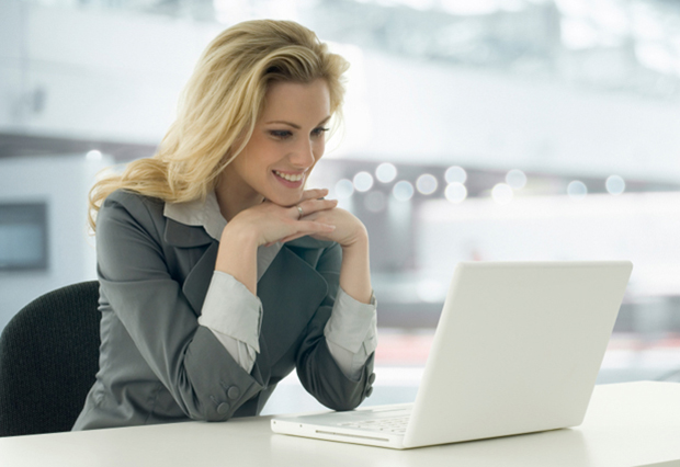 Image of lady looking at laptop and smiling