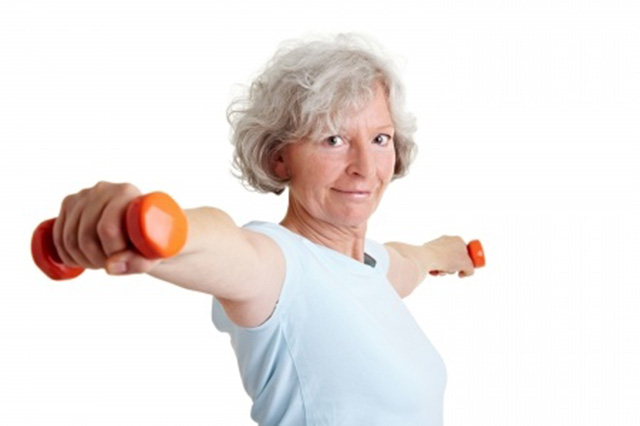 Image of older lady with arms outstretched holding weights