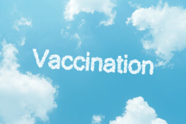 Sky view with cluds, blue sky and the word vaccination